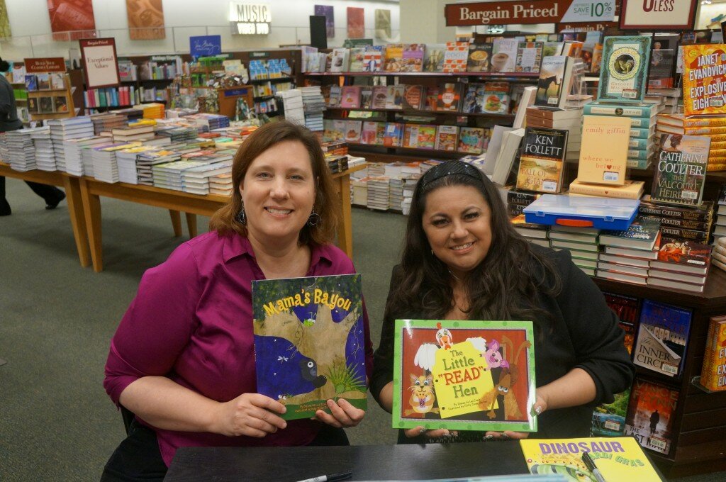 Holly Stone-Barker and Dianne de Las Casas sign copies of their books.